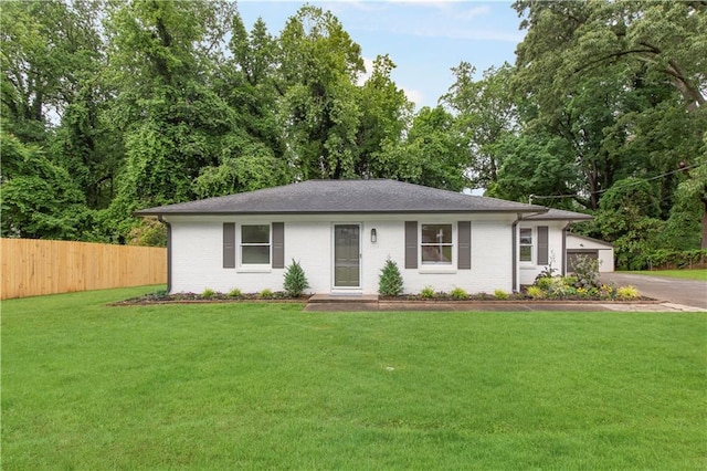 ranch-style house with brick siding, fence, and a front yard