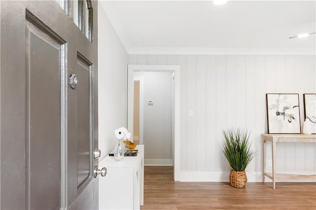 entryway featuring crown molding, baseboards, and wood finished floors