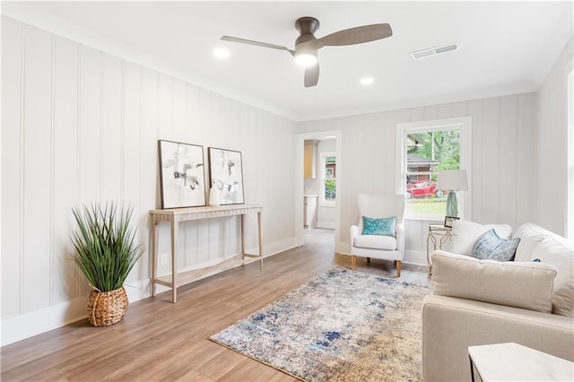 sitting room with ceiling fan, visible vents, crown molding, wood finished floors, and recessed lighting