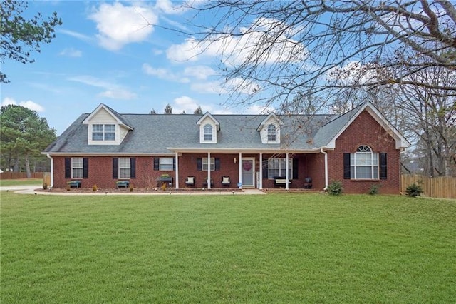 cape cod home with a front lawn and covered porch