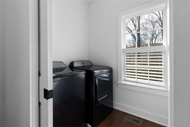 laundry area with baseboards, visible vents, washing machine and clothes dryer, laundry area, and dark wood-type flooring