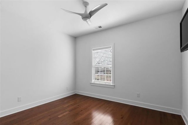 empty room with ceiling fan, dark wood-style floors, visible vents, and baseboards