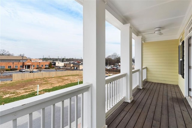 wooden deck with a residential view and a ceiling fan