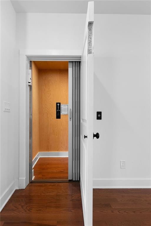 hall with baseboards and wood finished floors