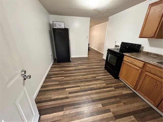 kitchen with black appliances, sink, dark hardwood / wood-style flooring, and a textured ceiling