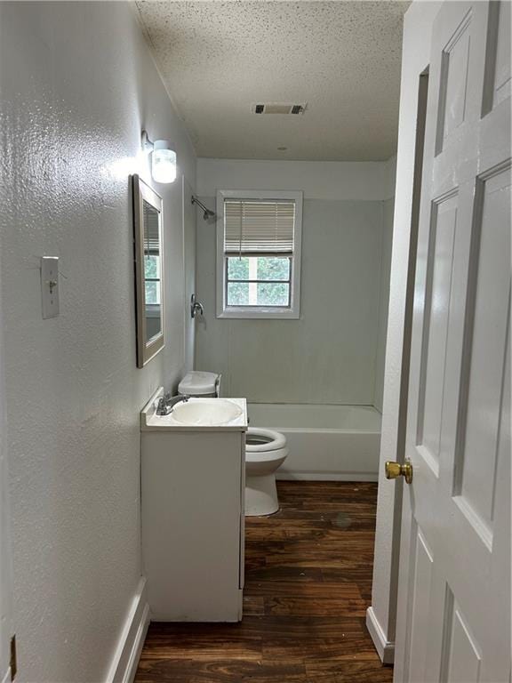 full bathroom with vanity, a textured ceiling,  shower combination, hardwood / wood-style floors, and toilet