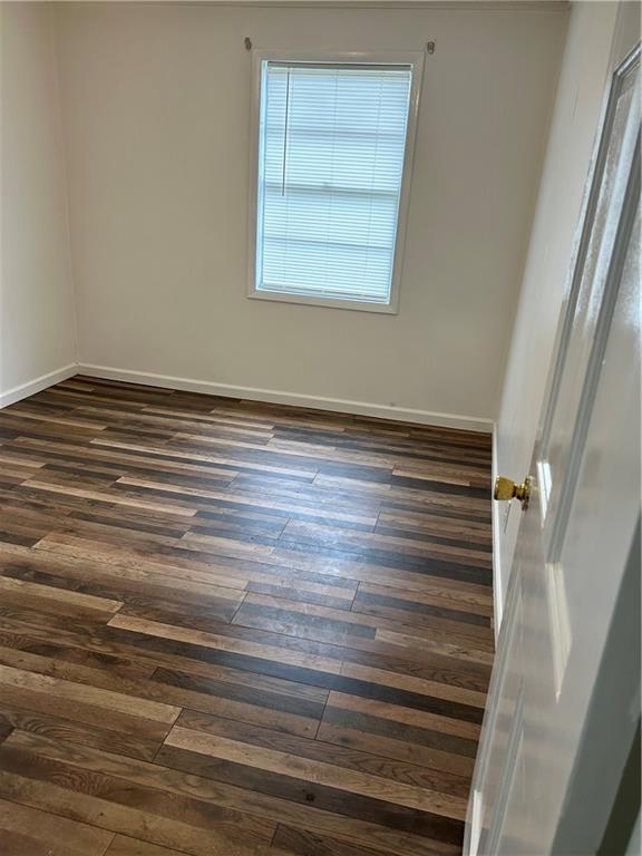 unfurnished room featuring dark hardwood / wood-style floors