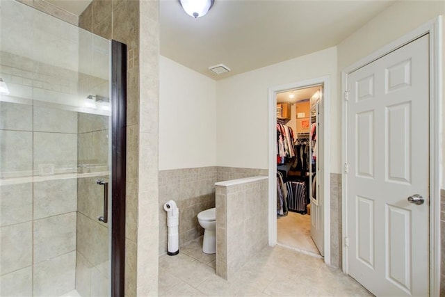 1360 Stampmill Way, Lawrenceville, GA 30043 - full bath featuring tile walls, a stall shower, tile patterned flooring, a wainscoted wall, and toilet