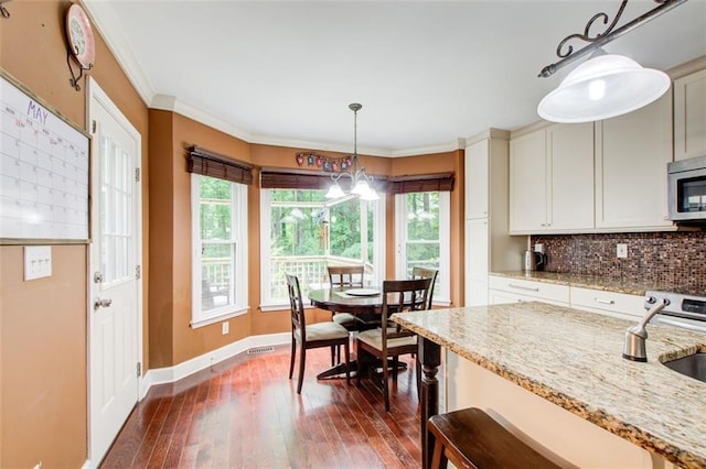 1360 Stampmill Way, Lawrenceville, GA 30043 - dining area featuring baseboards, dark wood-type flooring, a chandelier, and crown molding