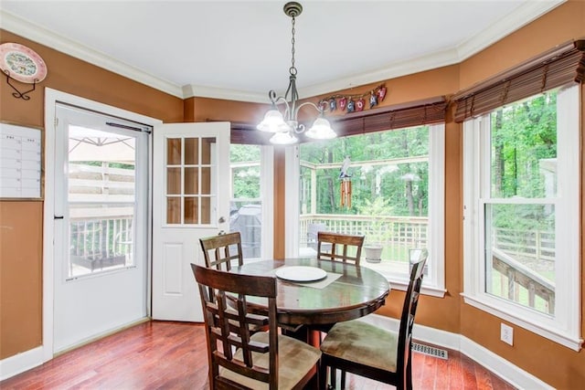 1360 Stampmill Way, Lawrenceville, GA 30043 - dining space featuring healthy amount of natural light, a chandelier, ornamental molding, wood finished floors, and baseboards