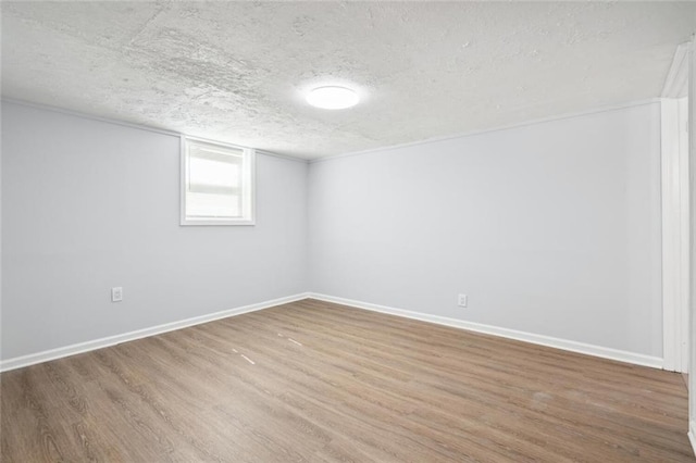 empty room featuring wood-type flooring and a textured ceiling