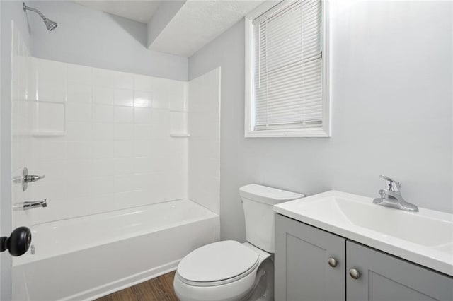 full bathroom with hardwood / wood-style flooring, vanity, toilet, and washtub / shower combination