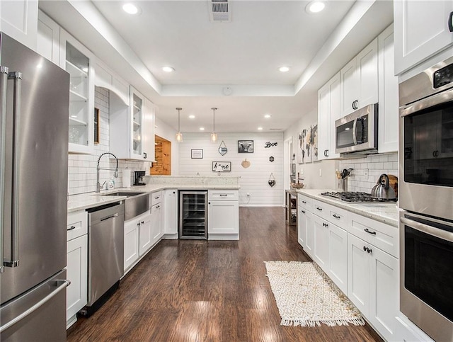 kitchen with decorative backsplash, stainless steel appliances, white cabinetry, dark hardwood / wood-style floors, and wine cooler