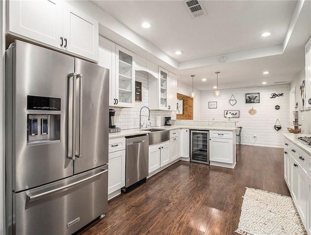 kitchen with stainless steel appliances, decorative light fixtures, white cabinetry, dark hardwood / wood-style floors, and wine cooler