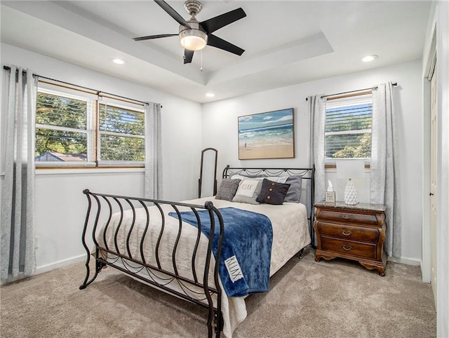 bedroom with light colored carpet, multiple windows, and ceiling fan