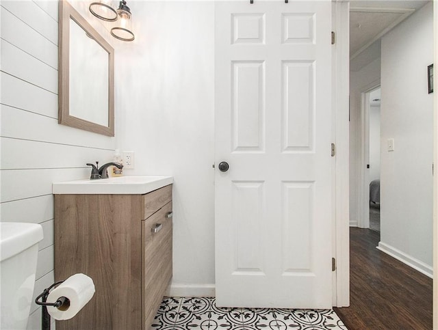 bathroom featuring vanity, wood-type flooring, and toilet