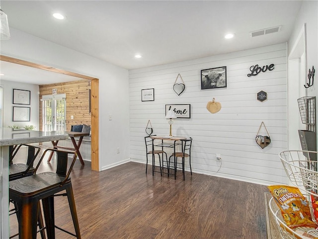 misc room with dark hardwood / wood-style flooring and wooden walls