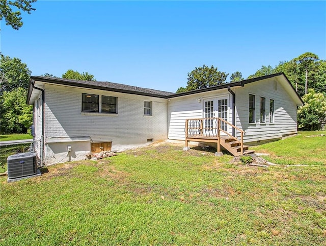 rear view of house with a yard and cooling unit