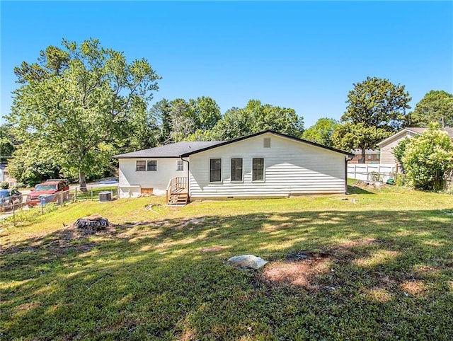 rear view of house with a lawn and central AC unit