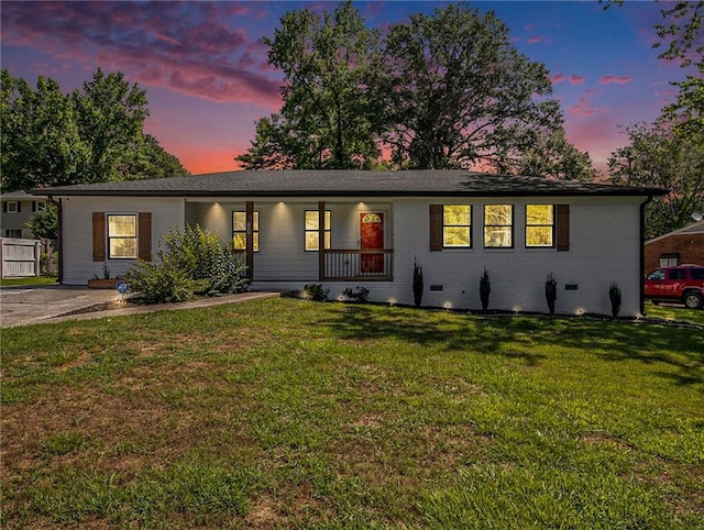 ranch-style house with covered porch and a yard