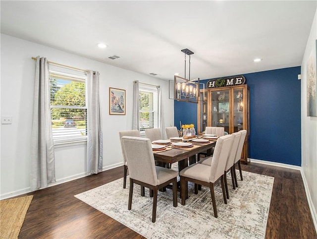 dining area featuring dark hardwood / wood-style flooring and a notable chandelier