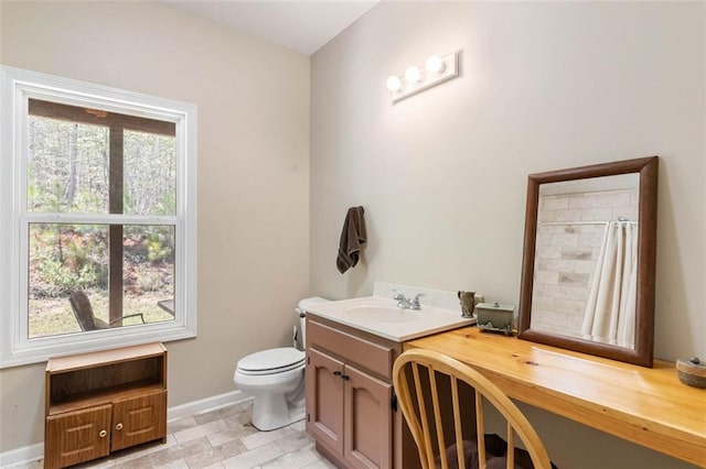 bathroom featuring tile flooring, vanity, and toilet