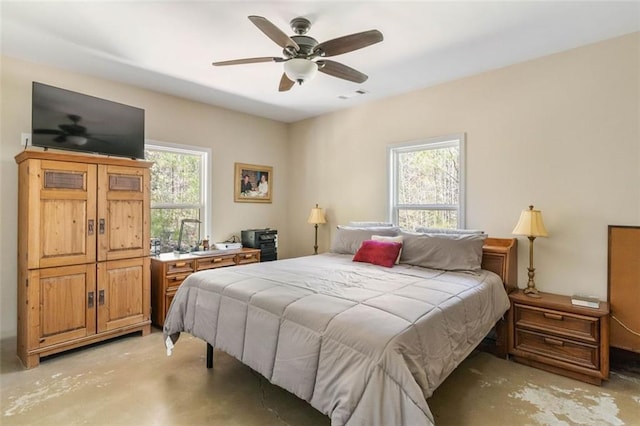 bedroom with ceiling fan and concrete flooring