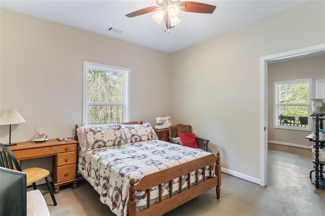 bedroom with ceiling fan and concrete flooring