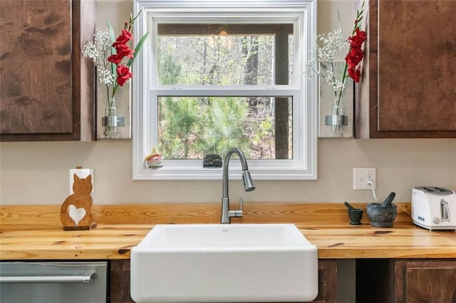 kitchen featuring plenty of natural light, sink, dishwasher, and wood counters