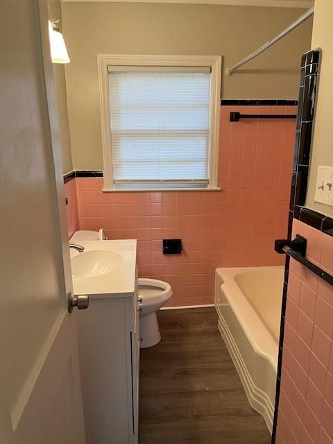 633 Tom Read Dr, Marietta, GA 30062 - full bath featuring tile walls, vanity, wood finished floors, a bath, and toilet