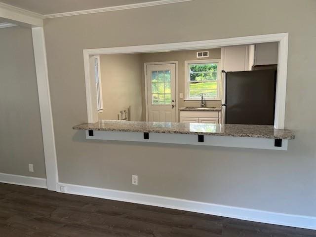633 Tom Read Dr, Marietta, GA 30062 - kitchen with freestanding refrigerator, ornamental molding, baseboards, dark wood-style floors, and light stone counters