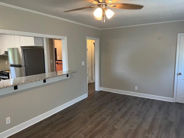 633 Tom Read Dr, Marietta, GA 30062 - empty room featuring dark wood-type flooring, a ceiling fan, crown molding, and baseboards
