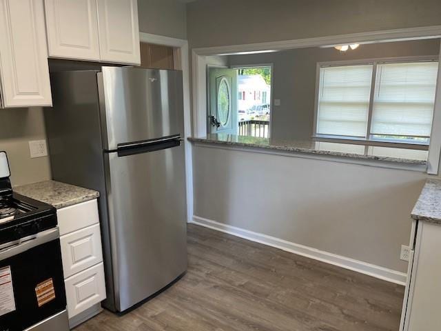 633 Tom Read Dr, Marietta, GA 30062 - kitchen with stainless steel appliances, white cabinetry, dark wood-style flooring, baseboards, and light stone counters