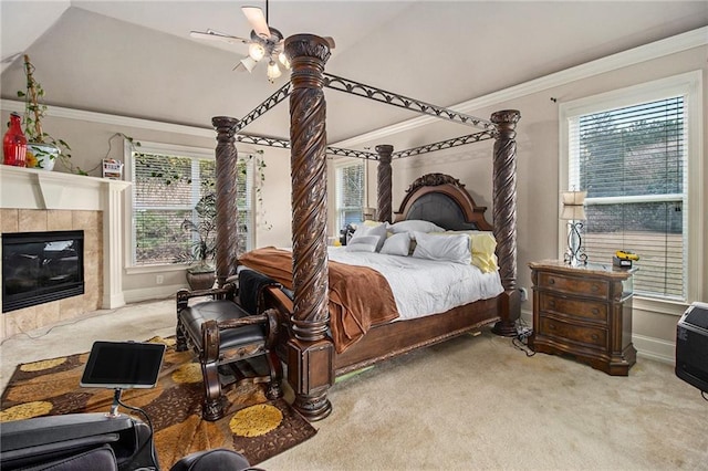 bedroom with crown molding, baseboards, vaulted ceiling, carpet floors, and a tile fireplace