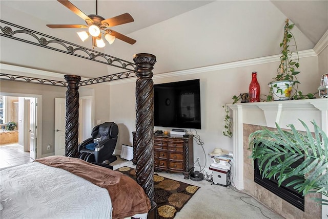 bedroom featuring carpet, lofted ceiling, a tile fireplace, ensuite bathroom, and crown molding