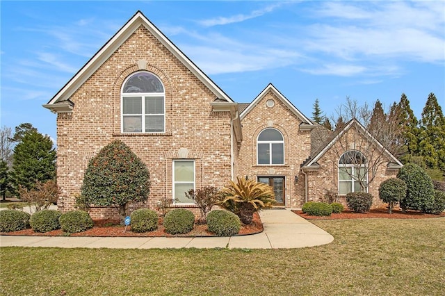 traditional home with a front lawn and brick siding