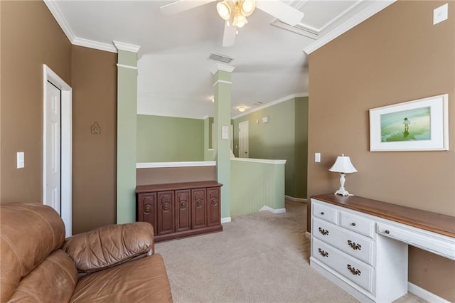 interior space featuring carpet, visible vents, decorative columns, ceiling fan, and crown molding