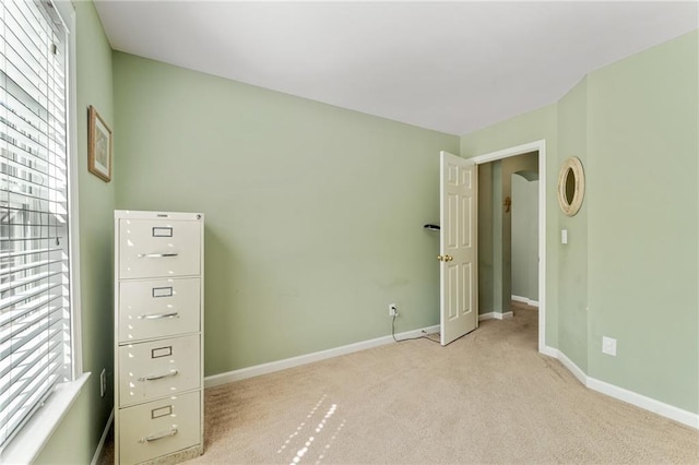 unfurnished bedroom with light colored carpet and baseboards