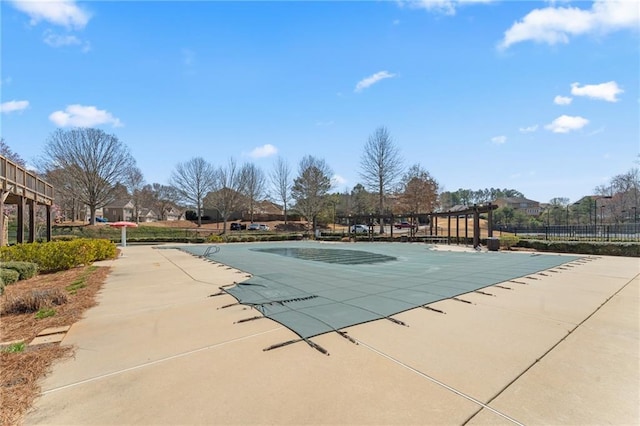 pool with a patio area and fence