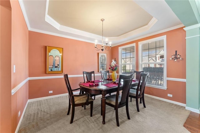 dining room with an inviting chandelier, crown molding, a raised ceiling, and baseboards