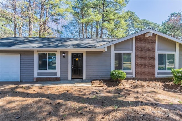 view of front of property featuring a garage and brick siding