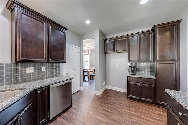 kitchen with dark hardwood / wood-style floors, dishwasher, backsplash, light stone countertops, and dark brown cabinets