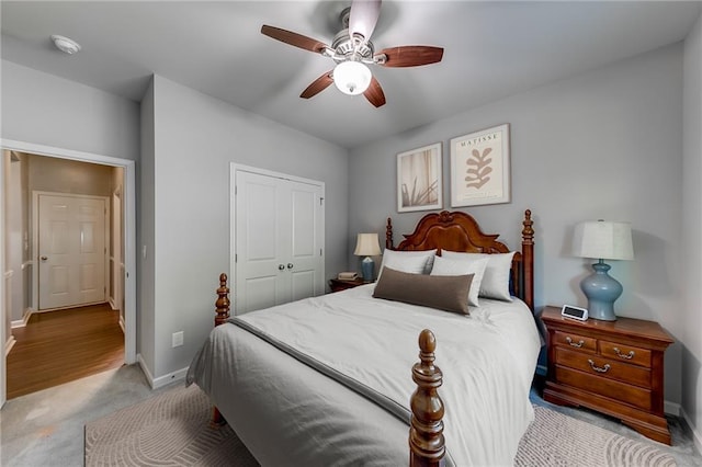 bedroom featuring ceiling fan, light colored carpet, and a closet