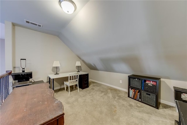 office with vaulted ceiling and light carpet