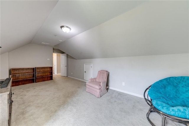 living area with carpet flooring and vaulted ceiling