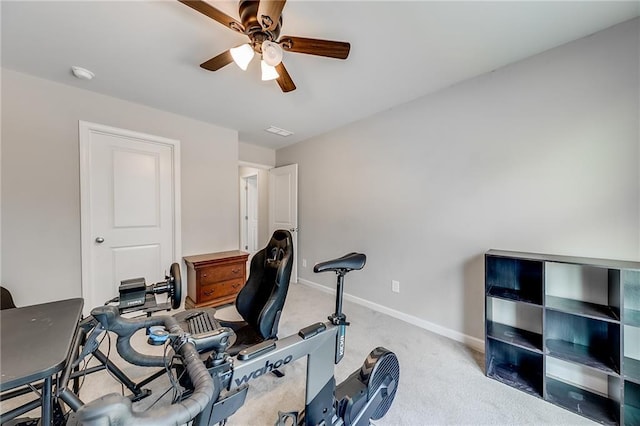 workout room featuring ceiling fan and light colored carpet