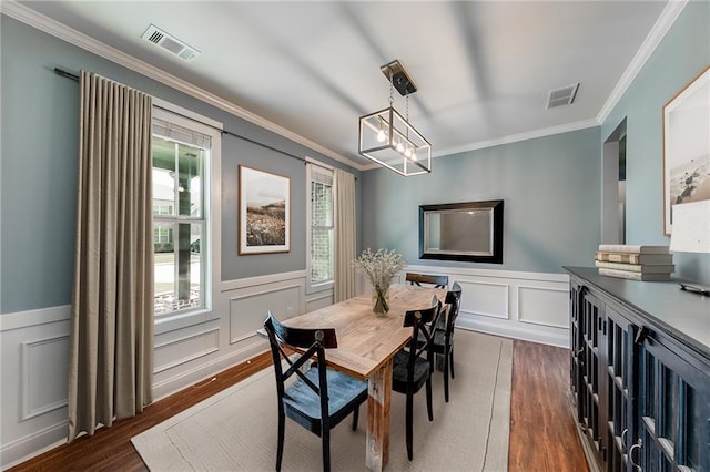 dining area featuring crown molding, dark hardwood / wood-style floors, and a chandelier