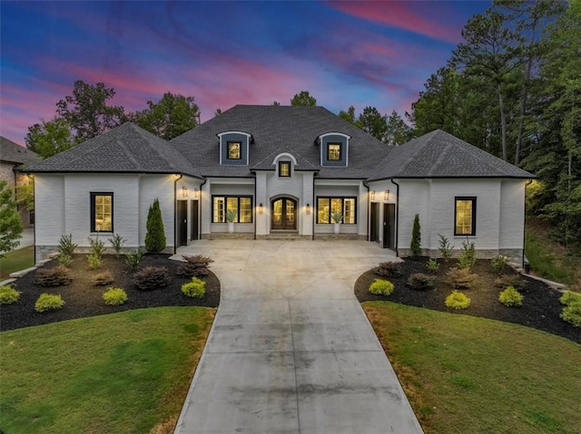 french country style house featuring a lawn