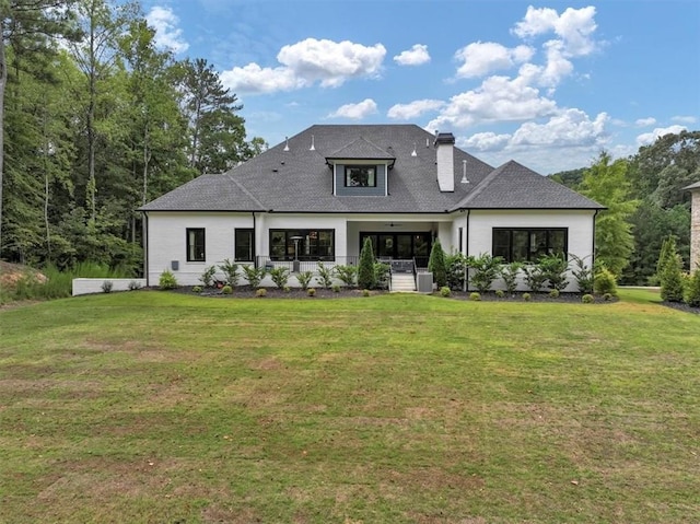 rear view of house featuring a lawn