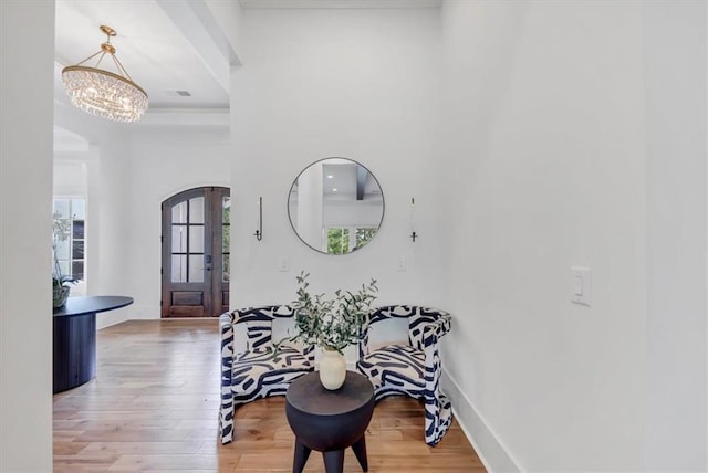 entryway with hardwood / wood-style floors and a chandelier